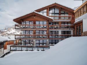 dom w śniegu z kupą śniegu w obiekcie Relais & Chateaux Schönegg w mieście Zermatt