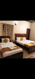 duas camas num quarto de hotel com saias em Luxury inn Rooms near Expo center , air port , agha khan em Carachi