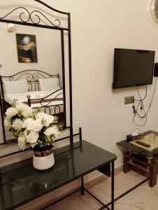 um quarto com um espelho e uma mesa com um vaso de flores em Luxury inn Rooms near Expo center , air port , agha khan em Carachi