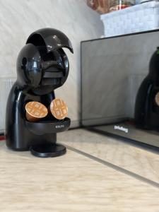 uma máquina de café segurando biscoitos na frente de uma TV em Vip Luxury APARTMENT em Burgas