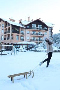 uma mulher puxando um banco na neve em СПА-Готель "RESPECT" em Skhidnitsa