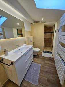 a bathroom with a white sink and a toilet at Sur les toits in Draguignan