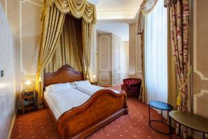 um quarto com uma cama de dossel grande em Hotel Château Cihelny em Karlovy Vary