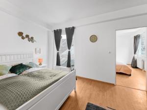 een witte slaapkamer met een bed en een raam bij Central Stockerau View 2 BR for 4 in Stockerau