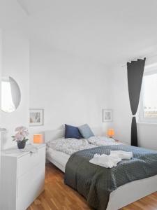 een witte slaapkamer met een bed en een raam bij Stockerau Comfort Studio 1 BR for 2 in Stockerau