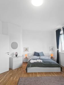 een witte slaapkamer met een bed en een witte muur bij Stockerau Comfort Studio 1 BR for 2 in Stockerau