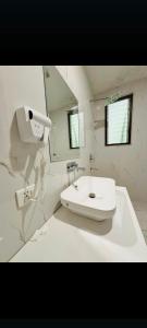 een witte badkamer met een toilet en een wastafel bij Hotel Shiva international near by IGI airport in New Delhi