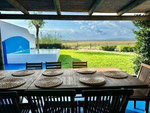 einen Holztisch mit Stühlen und Blick auf einen Hof in der Unterkunft Comporta - Wood & Blue in Comporta