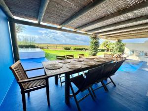 ein Esszimmer mit einem Tisch und Stühlen auf einer Terrasse in der Unterkunft Comporta - Wood & Blue in Comporta