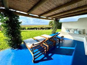 eine Terrasse mit einem Tisch und Stühlen auf einem blauen Boden in der Unterkunft Comporta - Wood & Blue in Comporta