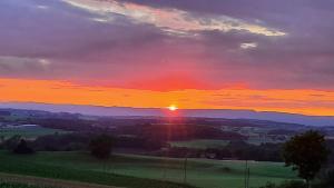 einen Sonnenuntergang über einem Feld mit Sonnenuntergang in der Unterkunft Chez Astrid in Treyvaux