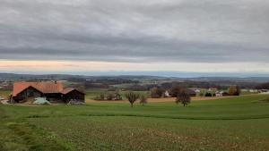 ein offenes Feld mit einer Scheune in der Ferne in der Unterkunft Chez Astrid in Treyvaux