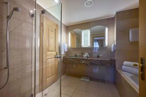 bagno con doccia in vetro e lavandino di Hotel Vereina a Klosters