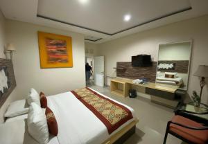 - une chambre avec un lit et une télévision dans l'établissement Batukaru Garden 5 Bali Sevilla Residence, à Canggu