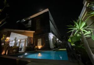 une villa avec une piscine la nuit dans l'établissement Batukaru Garden 5 Bali Sevilla Residence, à Canggu