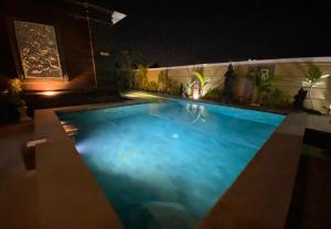 - une grande piscine d'eau bleue la nuit dans l'établissement Batukaru Garden 5 Bali Sevilla Residence, à Canggu