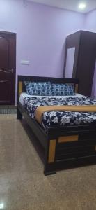 een bed in een kamer met een zwart frame bij Dream Stay Residency in Pondicherry