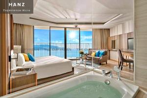 - une chambre avec un lit et une baignoire dans l'établissement HANZ Business Suite Panorama Grand Residences, à Nha Trang