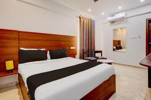 Collection O Airport INN في Yelahanka: غرفة نوم بسرير كبير في غرفة