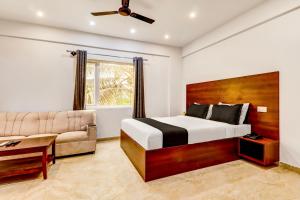 Collection O Airport INN في Yelahanka: غرفة نوم بسرير واريكة