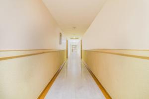 an empty corridor of a building with a long hallway at Capital O Grand Plaza in Coimbatore