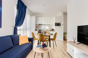 een woonkamer met een blauwe bank en een tafel bij ARI - AFI Mall Luxurious Apartments with Free Parking in Arad