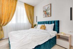 een slaapkamer met een groot bed met een blauw hoofdeinde bij ARI - AFI Mall Luxurious Apartments with Free Parking in Arad