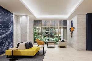 a living room with a yellow couch and chairs at Four Points Flex by Sheraton Osaka Umeda in Osaka