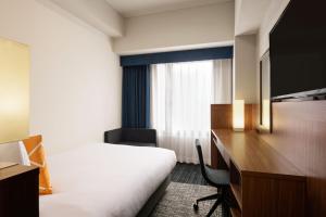 a hotel room with a bed and a desk at Four Points Flex by Sheraton Osaka Umeda in Osaka