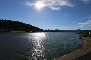 een uitzicht op een meer met de zon op het water bij Zagrodek Pizza & SPA in Gródek Nad Dunajcem