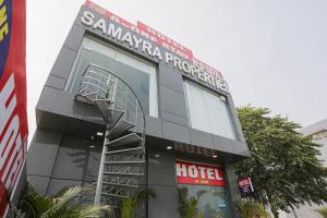 a hotel with a spiral staircase in front of a building at Capital O A-one in Manesar