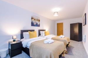 um quarto com 2 camas e toalhas em Court House Apartments em Bury