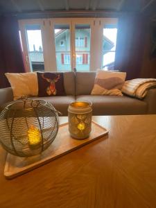 a living room with a couch and a candle on a table at Cosy apartment in heritage protected swiss chalet in Matten