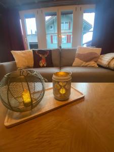 a living room with a couch and a candle on a tray at Cosy apartment in heritage protected swiss chalet in Matten