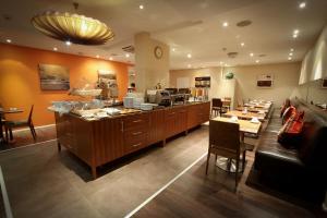 a restaurant with a kitchen with a table and chairs at Gresham Belson Hotel Brussels in Brussels