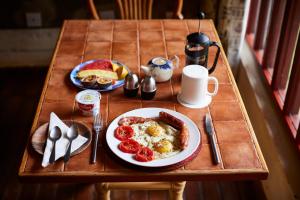 een ontbijttafel met een bord eieren en aardbeien bij Villa Rock Stop Falls in Nairobi