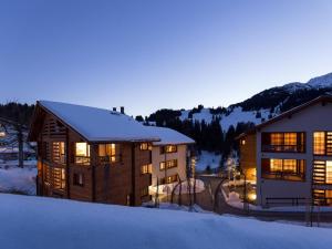 ein großes Gebäude mit Schnee auf dem Boden daneben. in der Unterkunft Apartment Turrabuel 2-Bett Superior by Interhome in Parpan