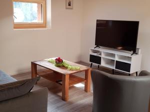 ein Wohnzimmer mit einem TV und einem Couchtisch in der Unterkunft Apartment Lischa by Interhome in Fiesch