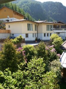 a group of houses with trees and flowers at Apart Andrea in Längenfeld