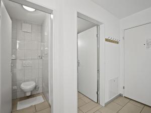 La salle de bains blanche est pourvue d'une douche et de toilettes. dans l'établissement Apartment Hemmadi by Interhome, à Churwalden