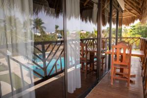 a balcony of a house with a table and chairs at Kabañas Ojo de Agua in Puerto Morelos