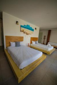 two beds in a hotel room with at Kabañas Ojo de Agua in Puerto Morelos