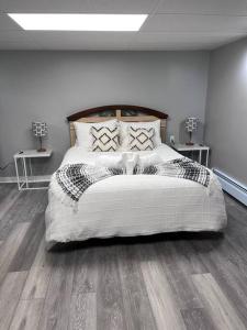 1 dormitorio con 1 cama grande y 2 mesas en Sweet Blossom Place, en Kentville