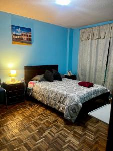 een slaapkamer met een bed en een blauwe muur bij Amplio y cómodo departamento. in Loja