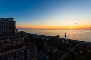 a sunset over the water in a city at VIP APARTmENTS N10 in Batumi