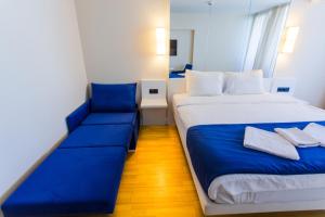 a bedroom with a large bed and a blue couch at VIP APARTmENTS N10 in Batumi