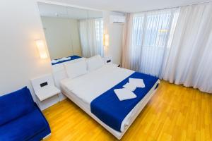 a bedroom with a large bed and a blue couch at VIP APARTmENTS N10 in Batumi