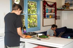 Eine Frau, die in einer Küche steht und Essen zubereitet. in der Unterkunft Apollo Bay Backpackers in Apollo Bay