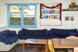 ein Wohnzimmer mit einem blauen Sofa und einem Tisch in der Unterkunft Apollo Bay Backpackers in Apollo Bay