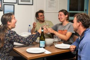 eine Gruppe von Menschen, die an einem Tisch sitzen und Wein trinken in der Unterkunft Apollo Bay Backpackers in Apollo Bay